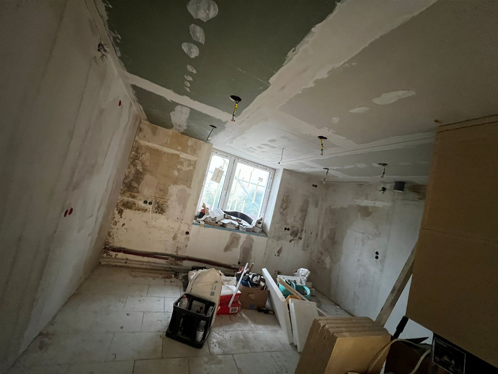 Zimmer mit zurückgebautem Wandputz und sichtbaren Feuchtespuren während einer Sanierung in Hannover