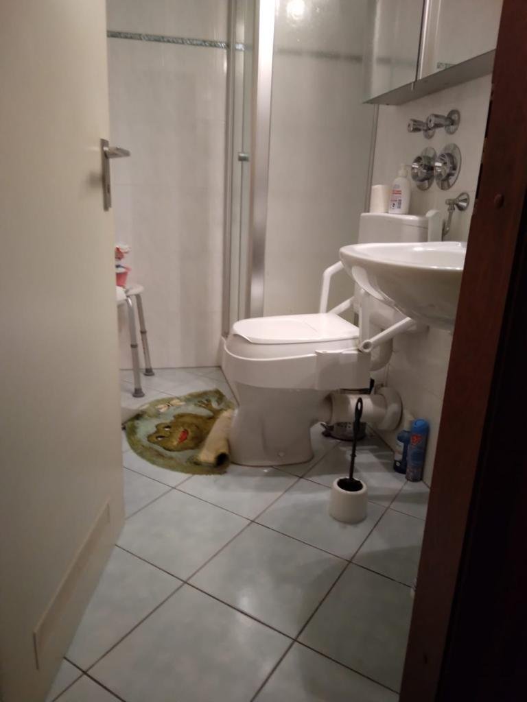 Kleines Badezimmer vor dem Umbau mit enger Duschkabine, erhöhtem WC und kleinformatigen Fliesen