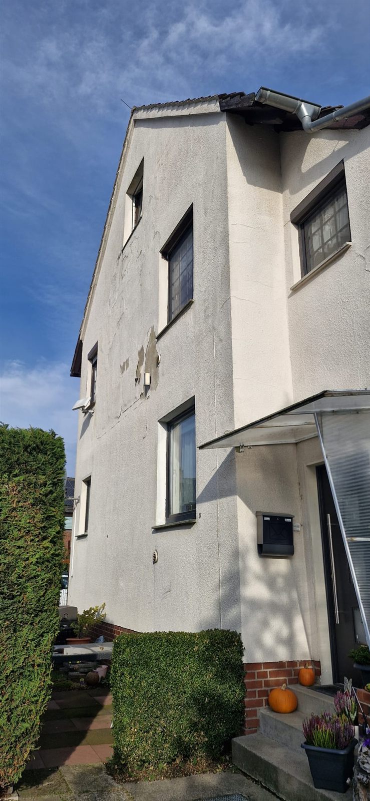 Giebelwand des Hauses in Garbsen vor der Sanierung mit Rissen und Putzschäden