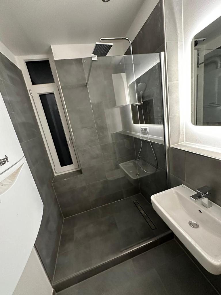 Neue bodengleiche Dusche mit Glastrennwand nach der Badsanierung