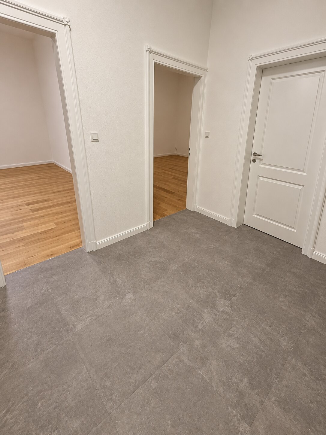 Wohnungssanierung in Hannover Nordstadt: fertiger Flur mit aufgearbeiteten Altbautüren und Parkett