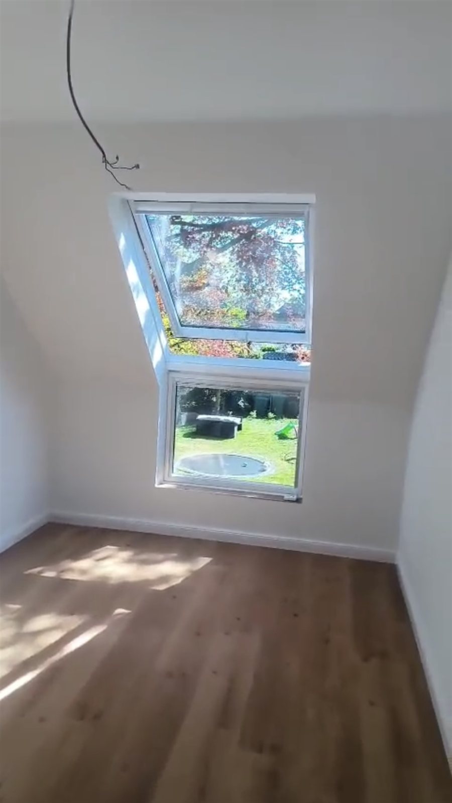 Fertiges Zimmer der Wohnung in Seelze mit Dachfenster und Gartenblick